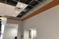 Ceiling and soffit wrap for a Jeep dealership using a custom 3M DiNoc woodgrain pattern.